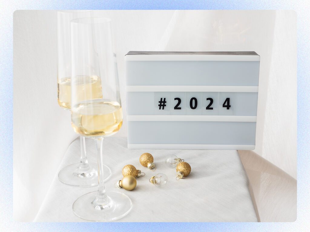 A stock photo of champagne glasses and a sign that says "#2024."