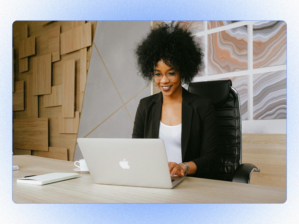 A stylized stock photo of a professional woman in the office working on a laptop. 